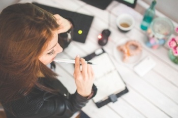 Woman at desk studying and thinking during a taster course