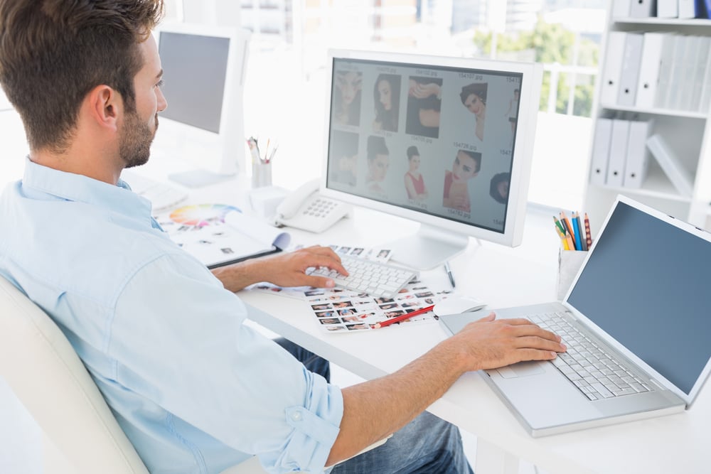 Side view of a male photo editor working on computer in a bright office