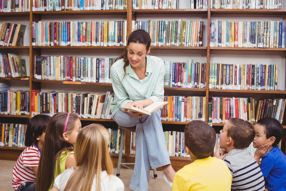 kids engaging listening to book read by teacher