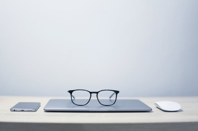 Trainer's glasses resting on training management software system