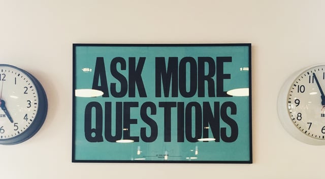 Ask more questions poster on wall