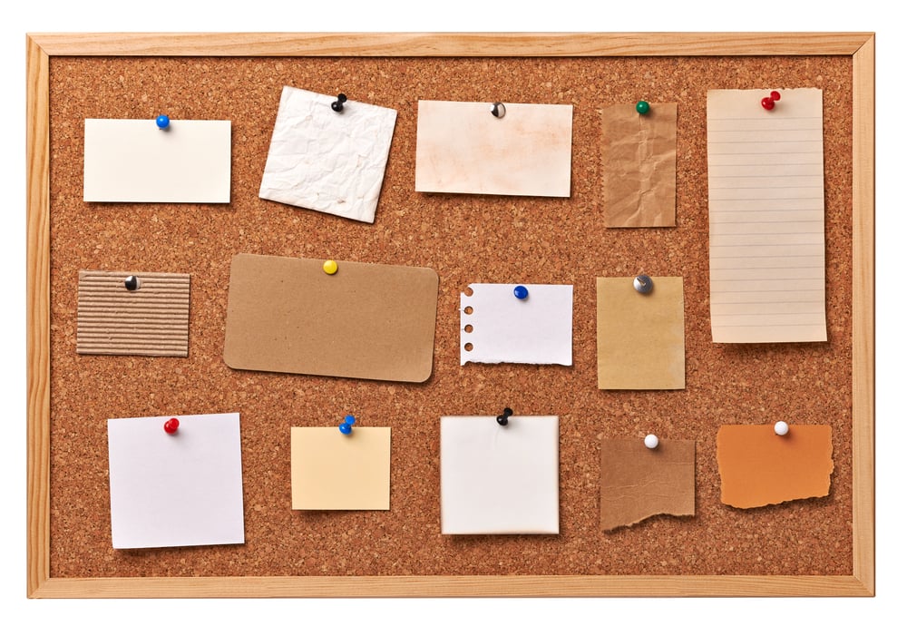 close up of note papers on a cork board