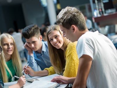 young adults working together laughing in classroom
