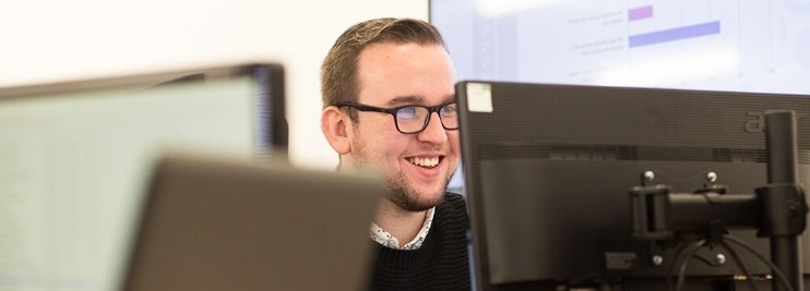 Man smiling at computer screen